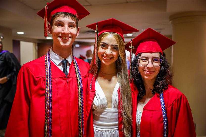 Students in red robes graduate